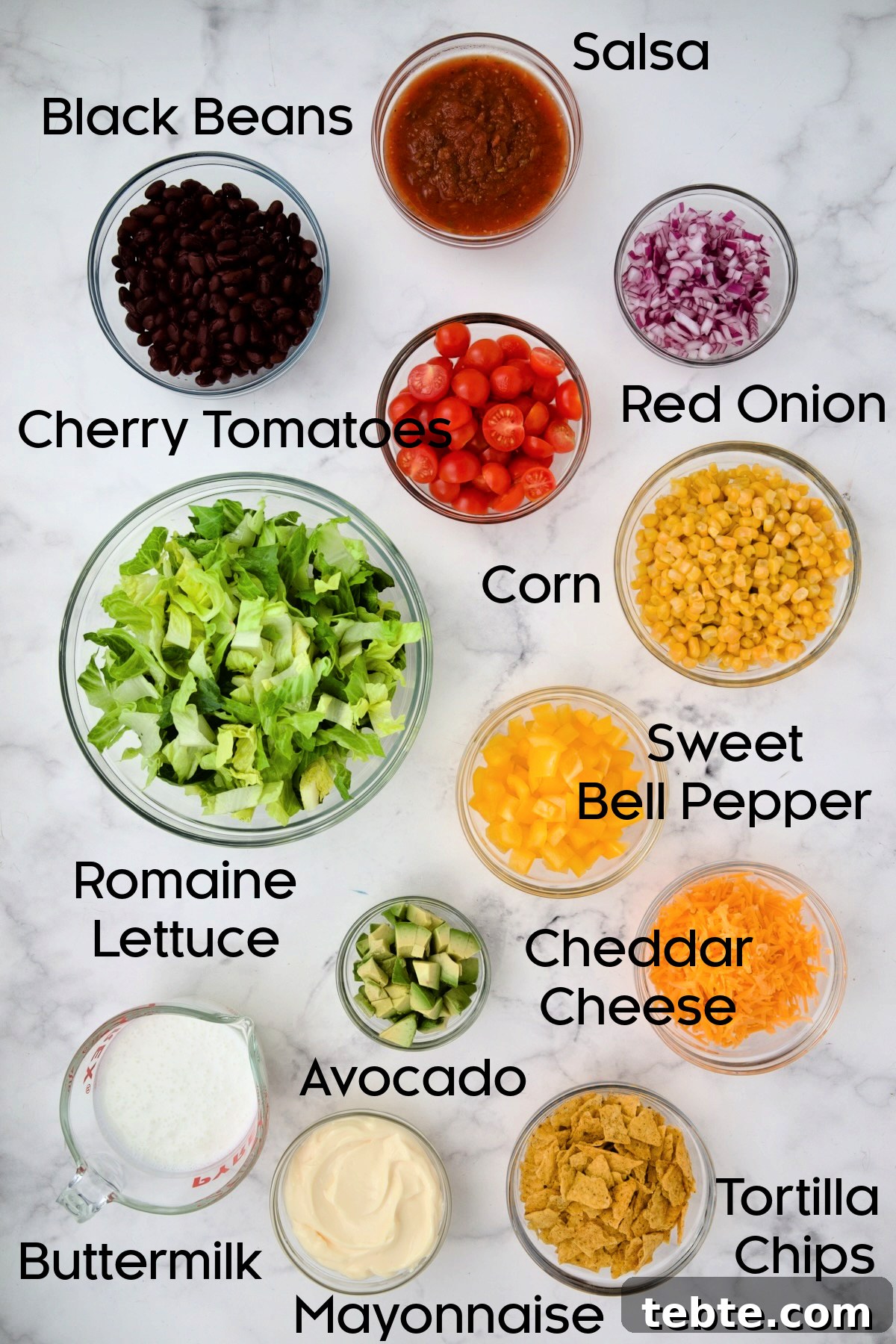 Layered Southwestern Salad with Corn, Black Beans, and Avocado 4 Ingredients for Southwestern Layered Salad in glass bowls.