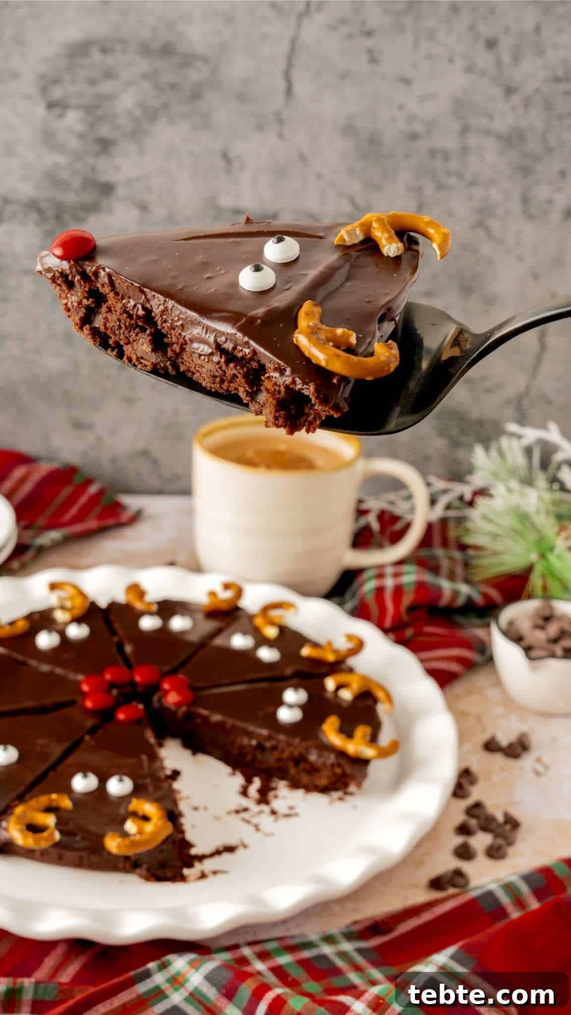 Reindeer Christmas Brownies Recipe for Festive Treats 5 A Reindeer brownie on a pie server hovering above a plate of Christmas brownies.
