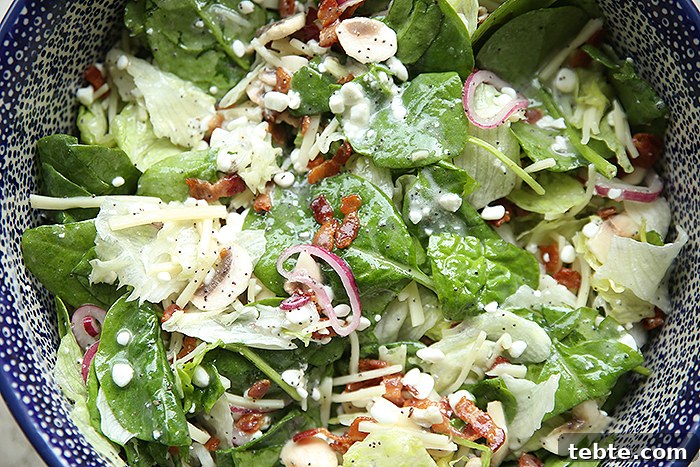 Fancy-Looking Christmas Eve Dinner Ideas for Busy Families 15 A horizontally placed white and blue polka-dotted Polish pottery bowl of Spinach Poppy Seed Salad.