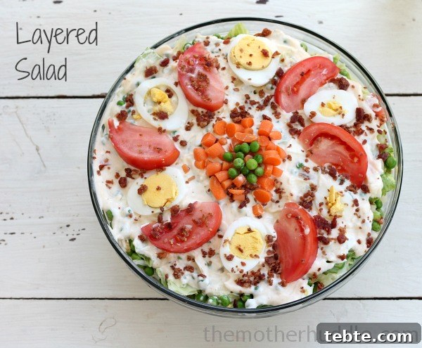 Fancy-Looking Christmas Eve Dinner Ideas for Busy Families 18 Layered Salad of lettuce, celery, water chestnuts, carrots, hard boiled eggs, crispy bacon, tomatoes, frozen peas, and dressing.