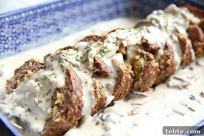 Fancy-Looking Christmas Eve Dinner Ideas for Busy Families 7 blue baking dish filled with stuffed meatloaf covered in a creamy mushroom gravy.