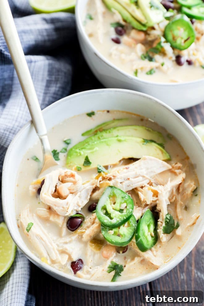 Creamy White Chicken Chili in the Slow Cooker 2 Bowl of white stew with vegetables and beans with spoon