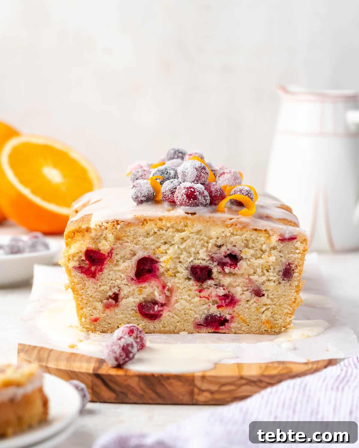 Classic Cranberry Orange Pound Cake Recipe 2 A loaf of cranberry orange pound cake sitting on a wood cutting board.