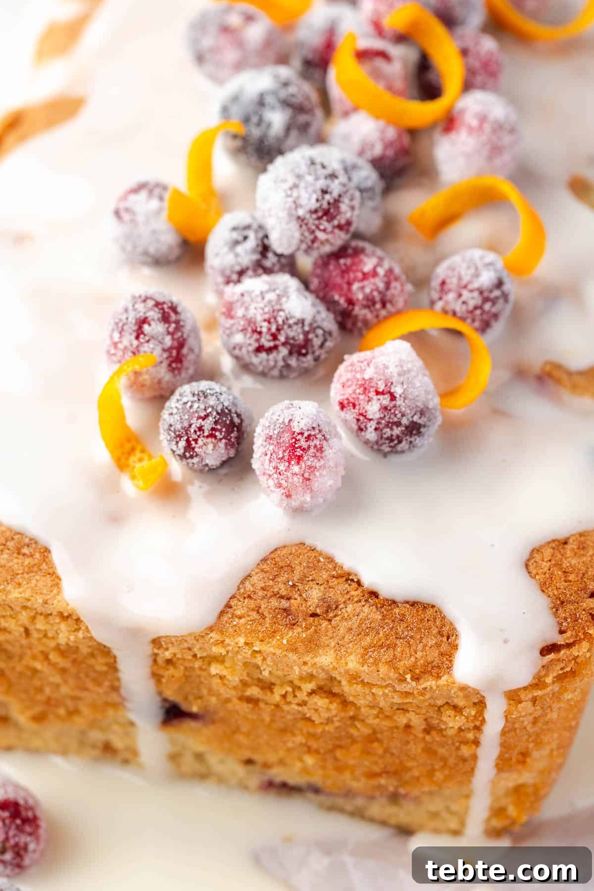 Classic Cranberry Orange Pound Cake Recipe 12 A cranberry orange pound cake topped with orange icing and sugared cranberries.