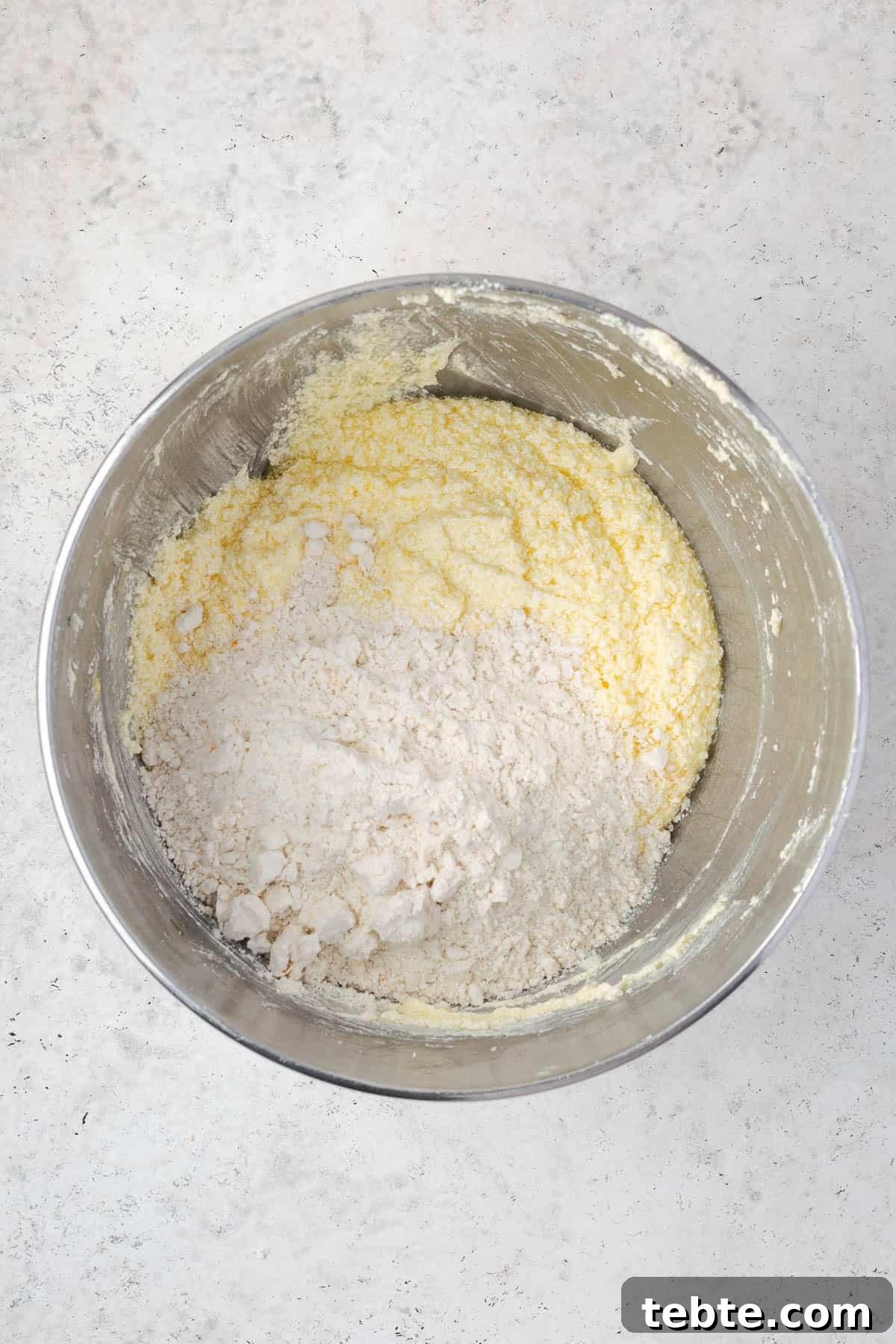 Classic Cranberry Orange Pound Cake Recipe 8 Dry ingredients being mixed into the wet ingredients.