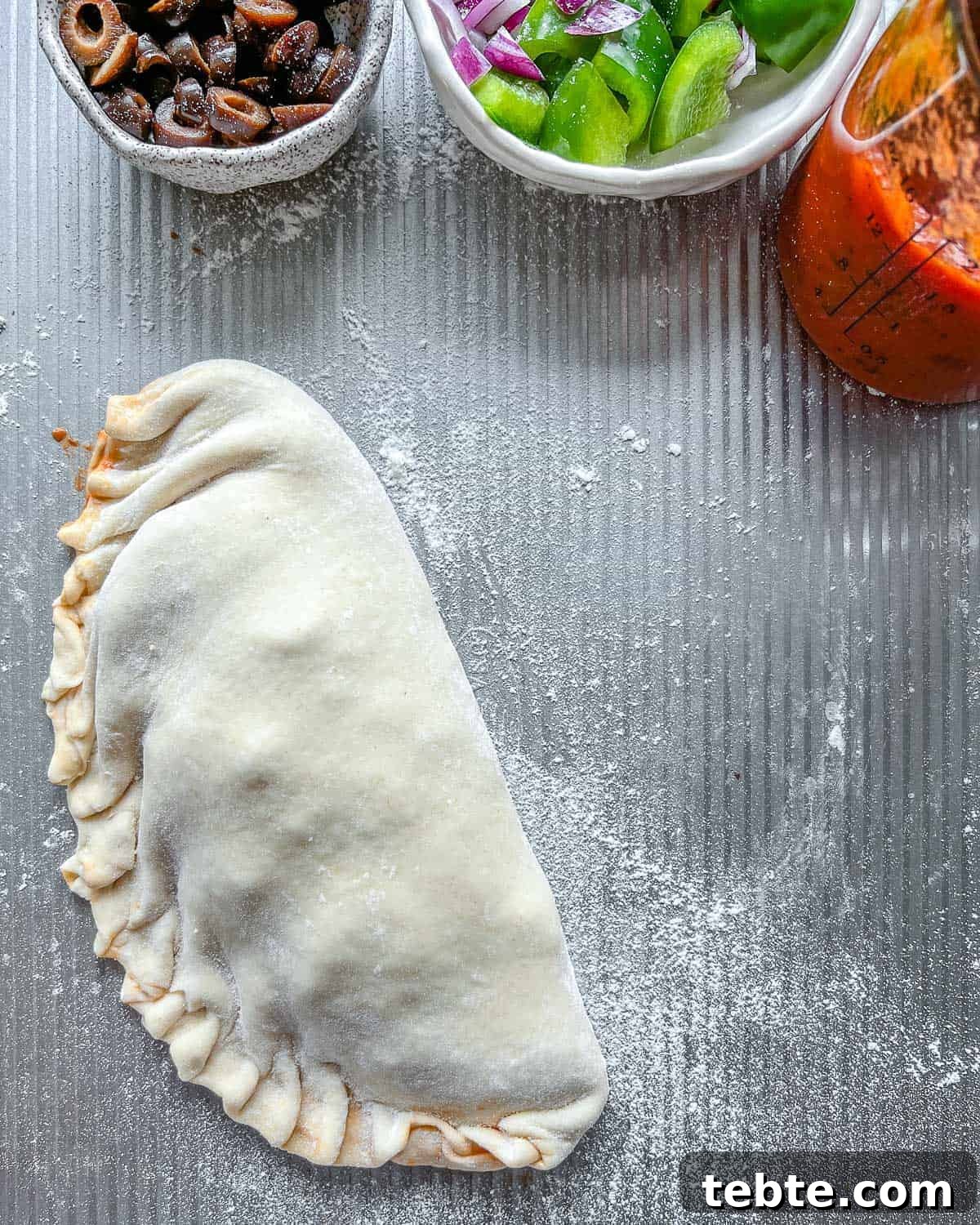 Vegan Calzones with Homemade Vegan Pizza Dough 12 one un-baked calzone on a gray surface