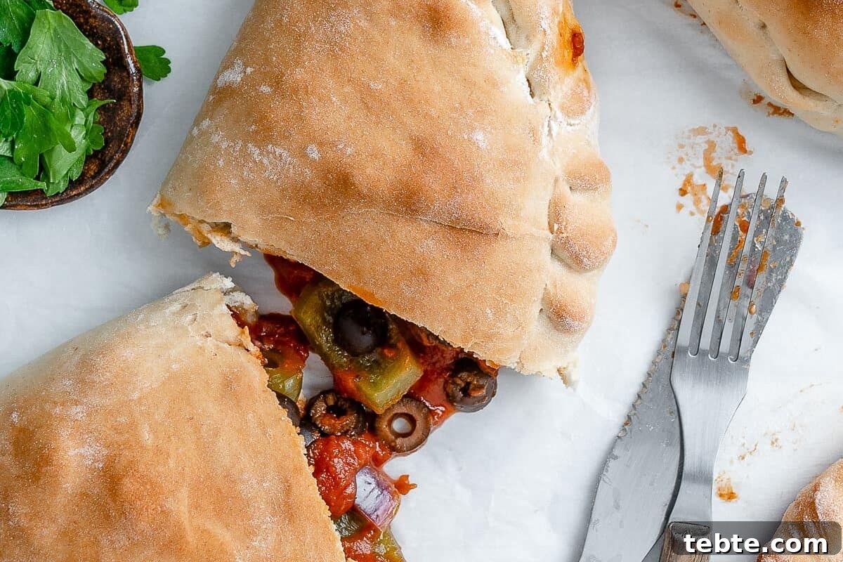Vegan Calzones with Homemade Vegan Pizza Dough 14 completed Marinara Calzone split open in the middle against white surface