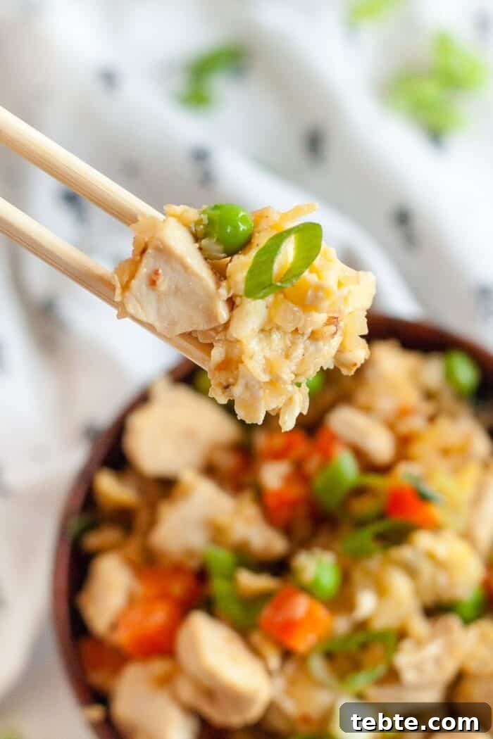Keto Egg Roll in a Bowl: Low-Carb One-Pan Recipe 9 chopsticks holding low carb chicken and rice over top a large bowl