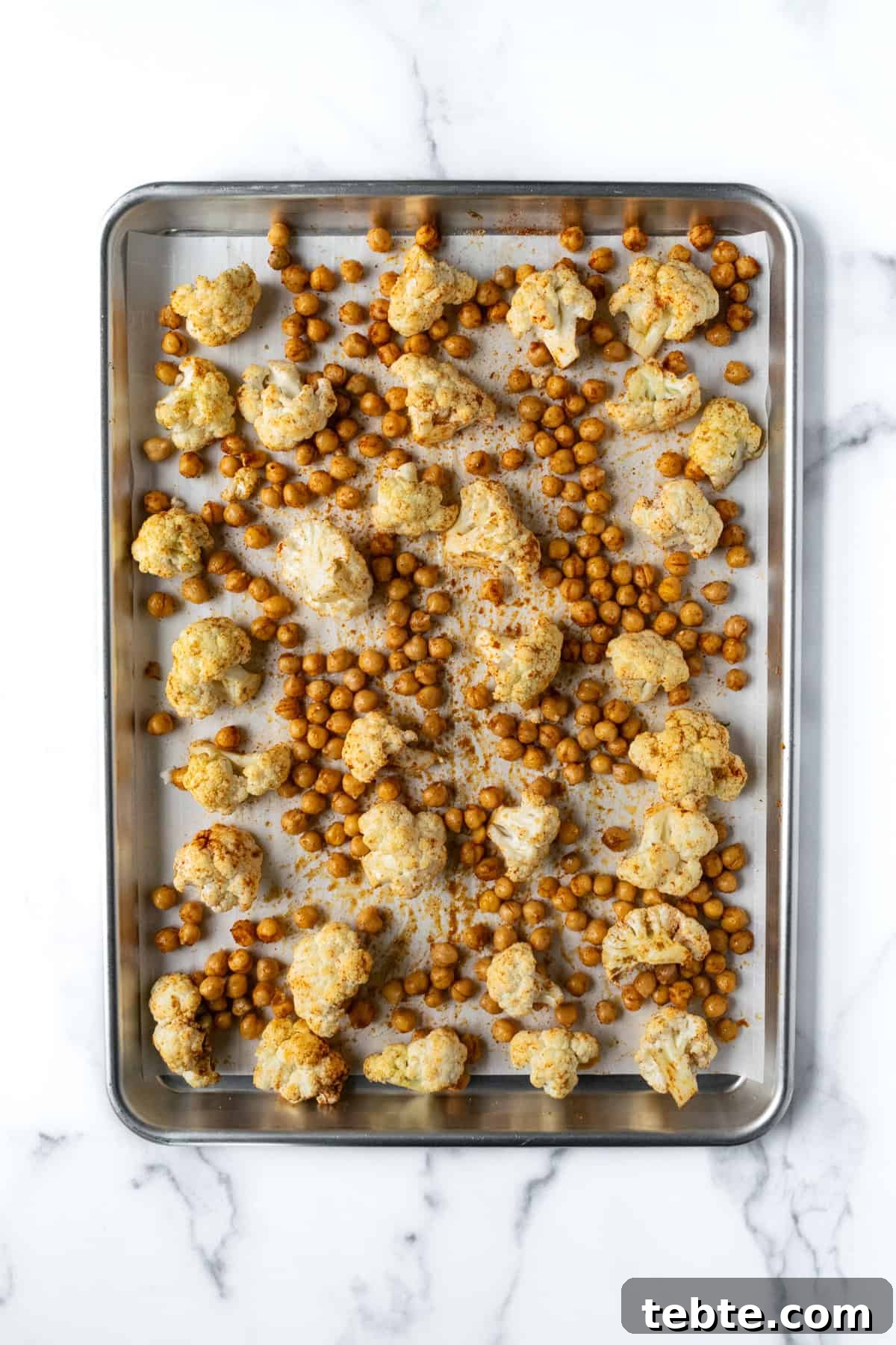 Crispy Roasted Cauliflower Bowl Recipes 4 Cauliflower and Chickpeas on a baking sheet ready to be baked.