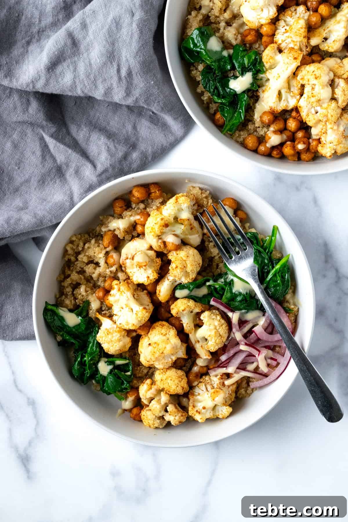 Crispy Roasted Cauliflower Bowl Recipes 6 Roasted Cauliflower and Chickpeas in a white bowl with quinoa, spinach, and pickled onions.