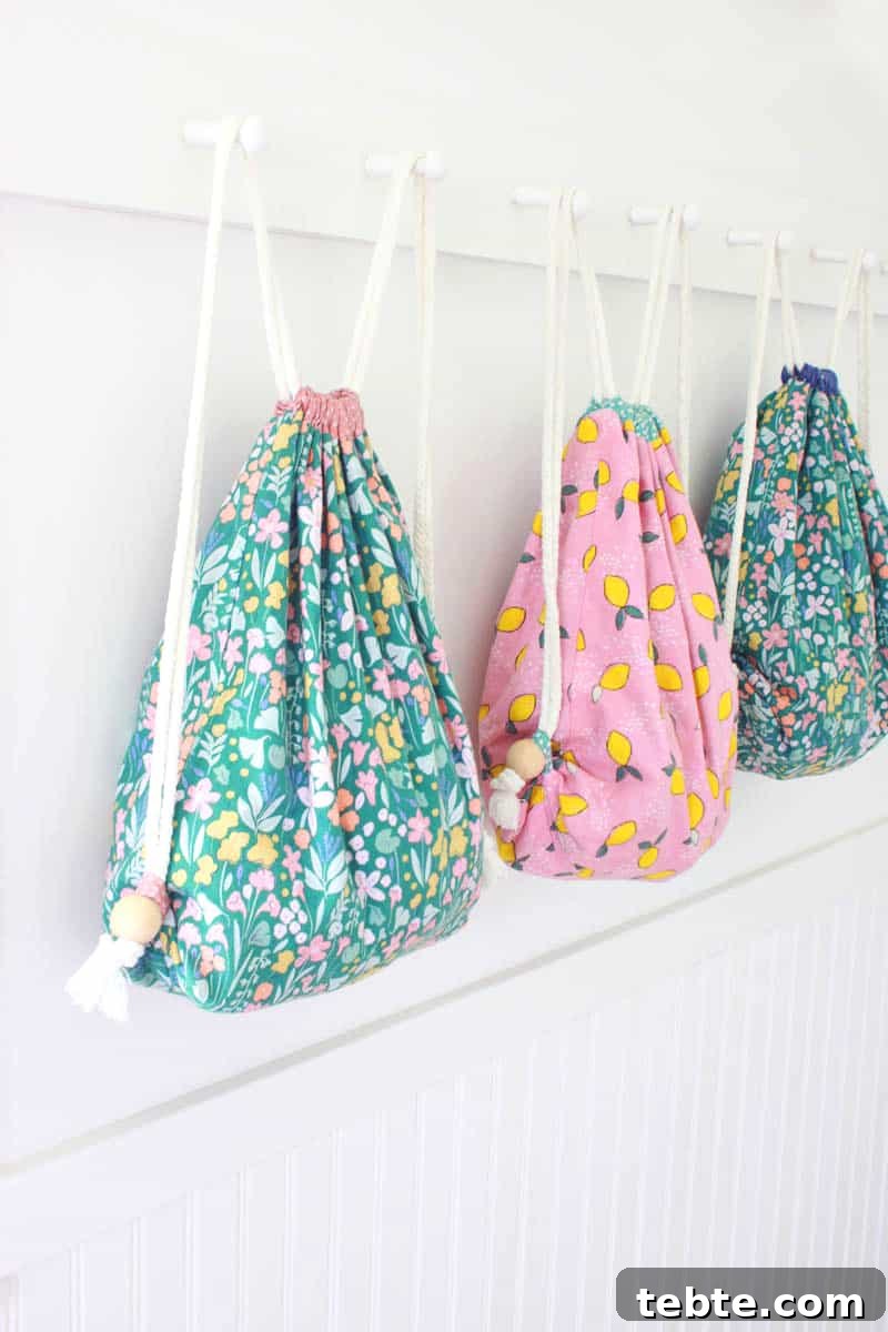 Sew a Drawstring Backpack: Step-by-Step Photo Tutorial 12 3 colorful lined drawstring backpacks lined up on a coat rack