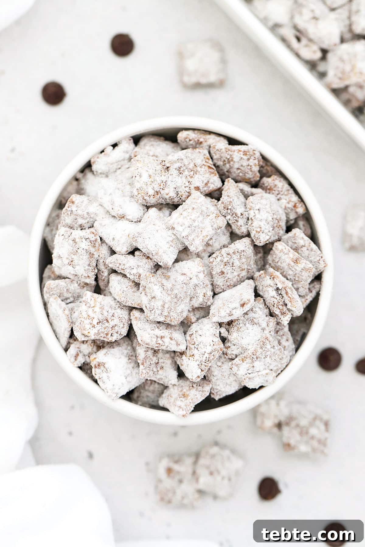 Gluten-Free Muddy Buddies Puppy Chow Recipe 2 gluten free muddy buddies in a white bowl